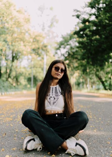 A woman sitting in the middle of a road