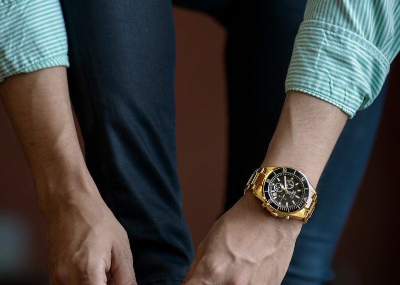 man tying his shoe laces while inside room during daytime