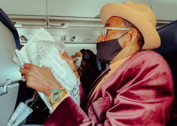 a man wearing a face mask while sitting in an airplane