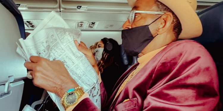 a man wearing a face mask while sitting in an airplane