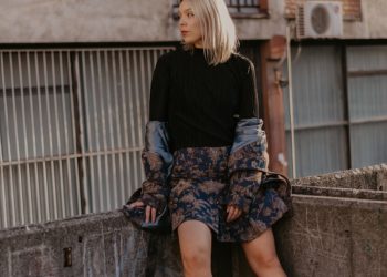 woman sitting on concrete railings at rooftop