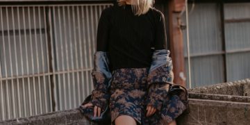 woman sitting on concrete railings at rooftop
