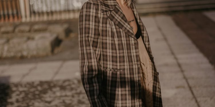 woman wearing brown and white plaid coat during daytime