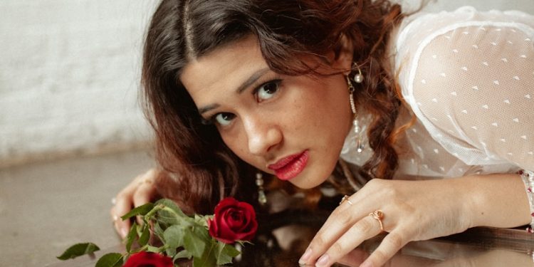 a woman holding a bouquet of roses in front of a mirror