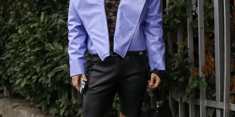 A man in a purple shirt and black shorts