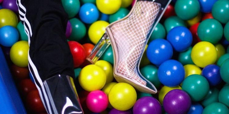 person sitting on assorted-color plastic ball lot